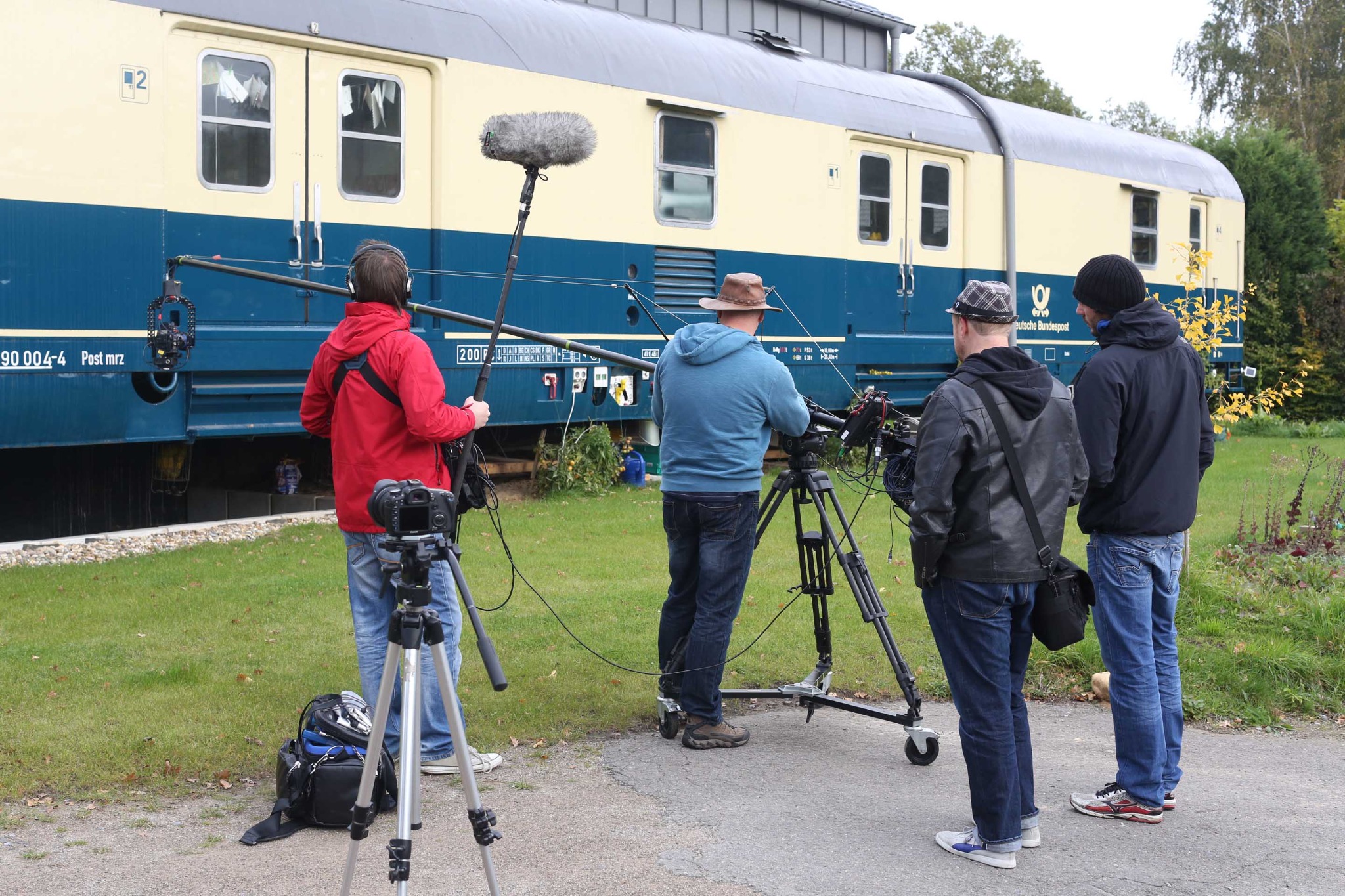 Filmteam bei Dreharbeiten vor einem Zug